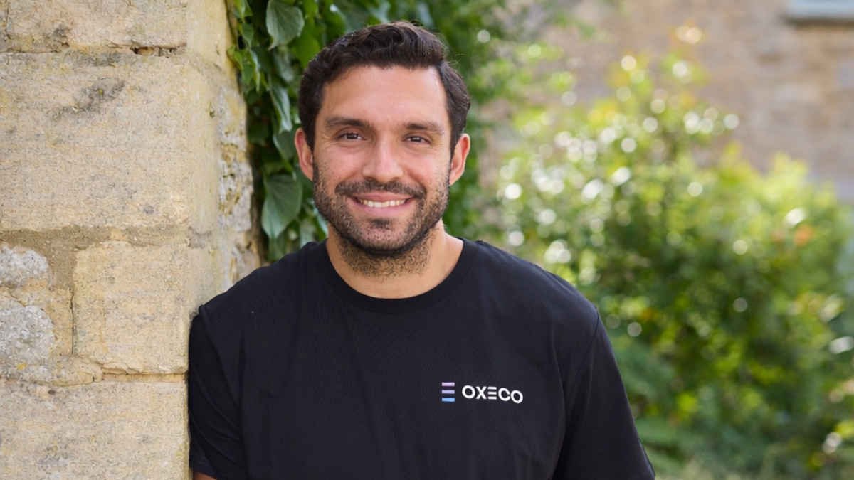 Portrait of Vass leaning against a wall on a sunny day
