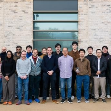 A research group standing in front of a new building